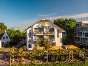 a hotel building with umbrellas in front of it at Hotel & Restaurant Seebrücke in Zingst