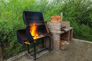 a barbecue grill with a fire in it at Las del Tatu in El Bolsón