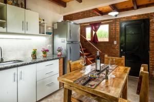 a kitchen with a wooden table and a refrigerator at Las del Tatu in El Bolsón