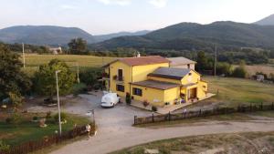 een geel huis met een auto ervoor geparkeerd bij B&B zio Domenico in Grumento Nova
