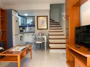 a living room with a table and a kitchen at Apartamento Gustamar 10 in Caleta De Fuste