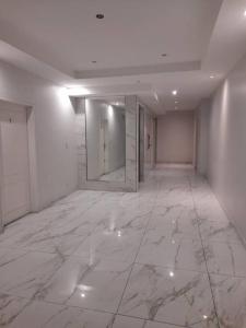 Jest to duży pokój z podłogą wyłożoną białym marmurem i dużym lustrem. w obiekcie Amplio monoambiente en edificio moderno w BuenosAires