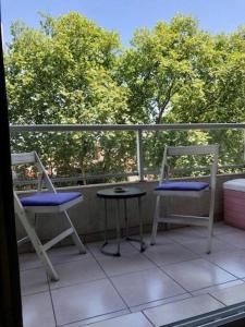 布宜諾斯艾利斯的住宿－Amplio monoambiente en edificio moderno，阳台配有2把椅子和1张桌子