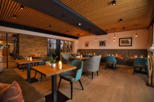 バート・ケッツティングにあるHotel Amberger Hofの木製の天井、テーブルと椅子のあるレストラン