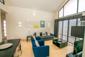 Una sala de estar con un sofá y un televisor. en 205 - Casa Santuario By Villas Now Ltd, en Playa Blanca