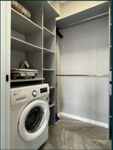 a washing machine in a laundry room with a closet at Lux 1-bedroom Most City Center area in Dnipro