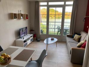 - un salon avec un canapé et une table dans l'établissement appartement au calme face au lac, à Marciac