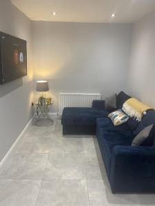a living room with a blue couch and a tv at Modern 3-Bed Apartment in Magherafelt Sleeps 8 in Magherafelt