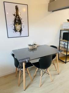 una mesa y sillas en una habitación con una foto en la pared en le Seize B en Épernay