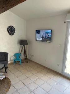 a living room with a tv on the wall at Appartement loft toit/terrasse in Sigean