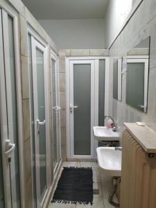 a bathroom with a shower and a sink and a mirror at Vacations in Patra Studios in Patra