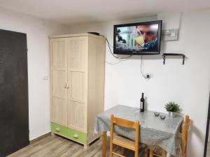 una sala da pranzo con tavolo e TV a parete di "פנינת עין כרם" יחידות ורד ואגוז a ‘En Kerem
