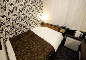 a bedroom with a bed with a black and white patterned wall at APA Hotel Nagano in Nagano