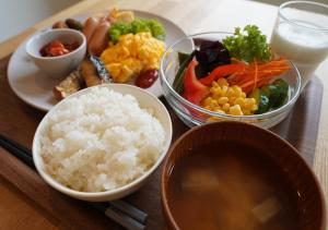 a wooden table with bowls of rice and vegetables at APA Hotel Nagano in Nagano