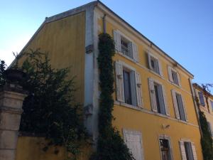 ラ・ロック・ダンテロンにあるChambre d'hôte Mas de Silvacaneの蔦の黄色の建物