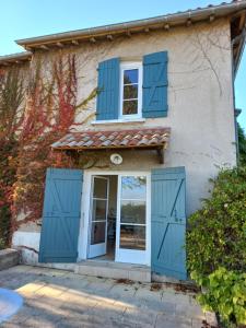 a house with blue doors and windows at L'Eglantyne in La Chapelle-de-Guinchay