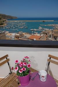 カステッランマーレ・デル・ゴルフォにあるMG Casevacanzaの港の景色を望むテーブルの上に花を飾るテーブル