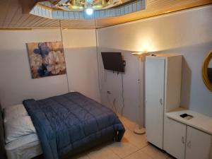 a bedroom with a bed and a tv on the wall at Preferred Place in Trincity 