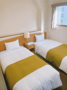 Tempat tidur dalam kamar di Fuchu Urban Hotel