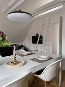 a white dining room table with two chairs and a light fixture at Ferienwohnung in Bad Bramstedt in Bad Bramstedt