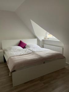 a bedroom with a white bed with a geometric headboard at Ferienwohnung in Bad Bramstedt in Bad Bramstedt