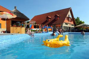 a pool with a yellow inflatable animal in the water at Wellness Park Pension in Gyenesdiás +11 photos
