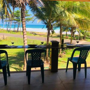 a table and chairs with a view of the beach at Turtles Nest Bunkhouse at Lodge at Long Bay in Corn Island
