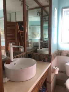 a bathroom with a sink and a large mirror at Turtles Nest Bunkhouse at Lodge at Long Bay in Corn Island