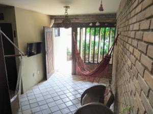 Apartamento/Duplex Praia do Francês في برايا دو فرانسيس: غرفة مع شرفة وأرجوحة فيها