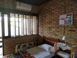 Apartamento/Duplex Praia do Francês في برايا دو فرانسيس: غرفة نوم بها سرير وجدار من الطوب