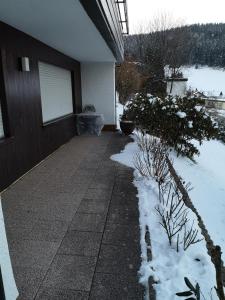 a porch of a house with snow on the ground at Ferien am Wald in Baiersbronn