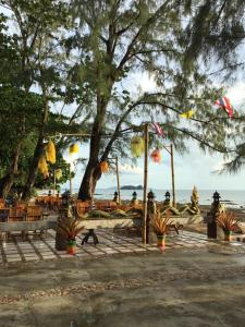 a park with benches and a tree and the beach at Andaman Beach Resort Koh Jum in Ko Jum