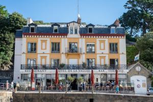 a large yellow building with people standing in front of it at Hôtel De La Vallée in Dinard
