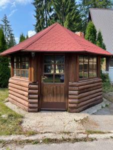 a small wooden cabin with a red roof at Apartmani Megara Vlasic in Šišava +8 photos