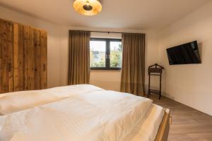 1 dormitorio con cama blanca y ventana en LODGE7 by Woods Lodge, en Seefeld in Tirol