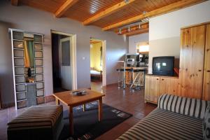 a living room with a couch and a tv at Wellness Park Pension in Gyenesdiás