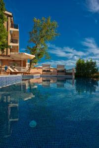 a swimming pool in front of a building at Harmonia Bungalows & Pool in Sveti Stefan