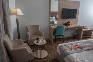 ターイフにあるFiori Hotelsのベッド、デスク、椅子が備わるホテルルームです。