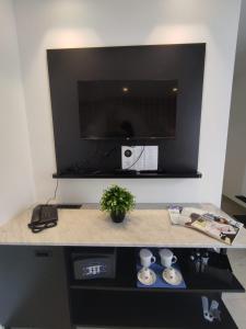 a counter with a tv and a table with two cups at The G Hotel by JL in St Julian's