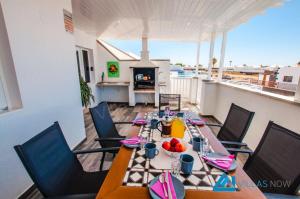 comedor con mesa y sillas en el balcón en Villa Graciosa By Villas Now Ltd, en Playa Blanca