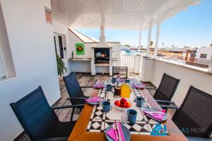 een eetkamer met een tafel en stoelen op een balkon bij Villa Graciosa By Villas Now Ltd in Playa Blanca