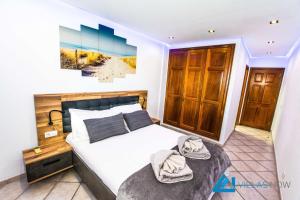 een slaapkamer met een bed met handdoeken erop bij Villa Graciosa By Villas Now Ltd in Playa Blanca