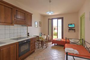 a kitchen with wooden cabinets and a living room with a table at Casale del Conero in Porto Recanati