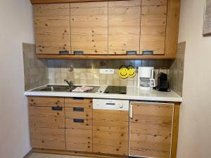 a small kitchen with a sink and wooden cabinets at Landhaus Mayer in Oberstdorf