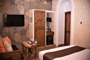 Habitación de hotel con cama y TV en Caucasus Hotel, en Ereván