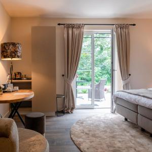 a bedroom with a bed and a door to a patio at KerkHotel Biervliet in Biervliet