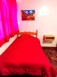 a red bed with red curtains in a room at Vacahouse Hostel - Huaraz in Huaraz