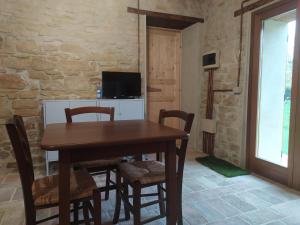 una sala da pranzo con tavolo e sedie in legno di Magione Broccoli a Candelara