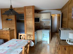 - une cuisine avec des murs en bois et une table dans une chambre dans l'établissement T2 vue piste Résidence Vostok Zodiaque, au Corbier