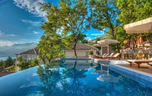 a swimming pool with a view of the mountains at Harmonia Bungalows & Pool in Sveti Stefan